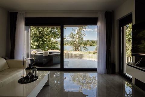 Bright modern living room with floor-to-ceiling sliding windows overlooking trees and water